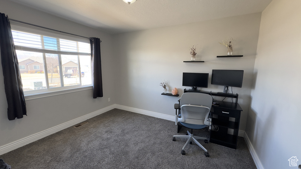 Office space featuring carpet flooring, visible vents, and baseboards