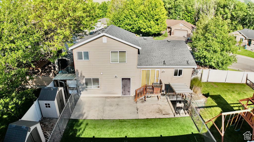 Rear view of property featuring a patio and roof with shingles