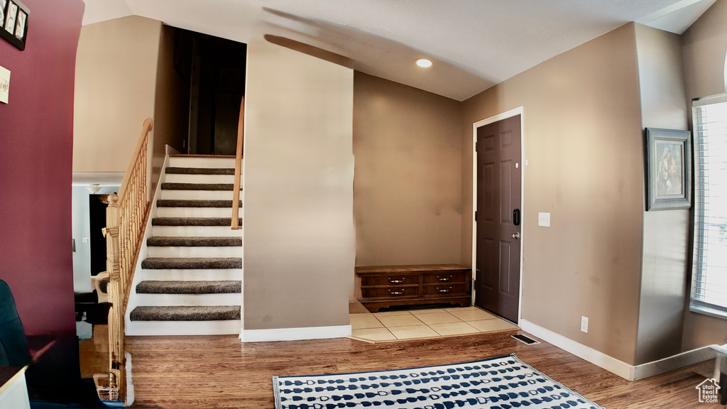 Foyer featuring light wood finished floors, stairs, baseboards, and recessed lighting