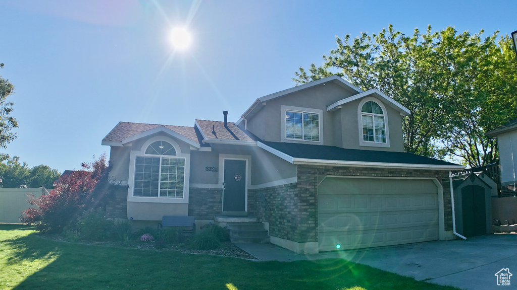 View of front facade featuring stucco siding, an attached garage, driveway, stone siding, and entry steps