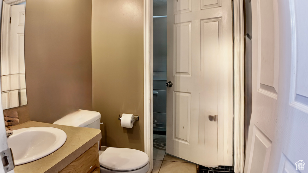 Bathroom with toilet, vanity, and tile patterned flooring
