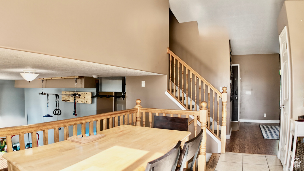 Dining area with tile patterned flooring, stairway, and baseboards