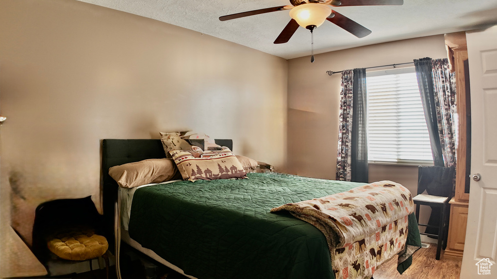 Bedroom featuring wood finished floors, ceiling fan, and a textured ceiling