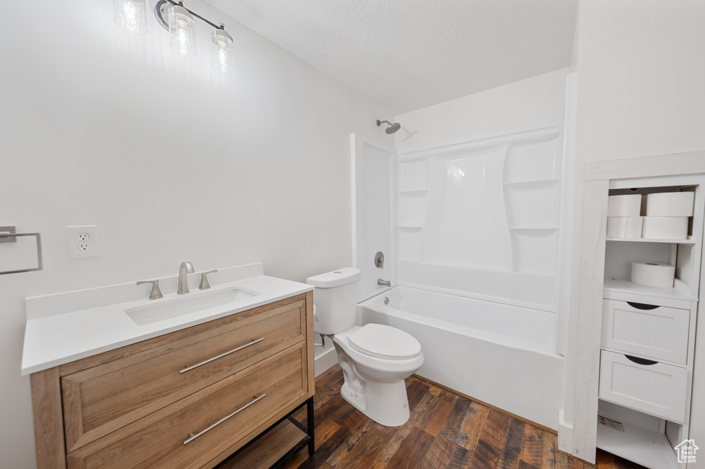 Bathroom featuring wood finished floors, vanity, and washtub / shower combination