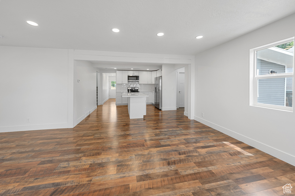 Unfurnished living room with recessed lighting and dark wood-style flooring