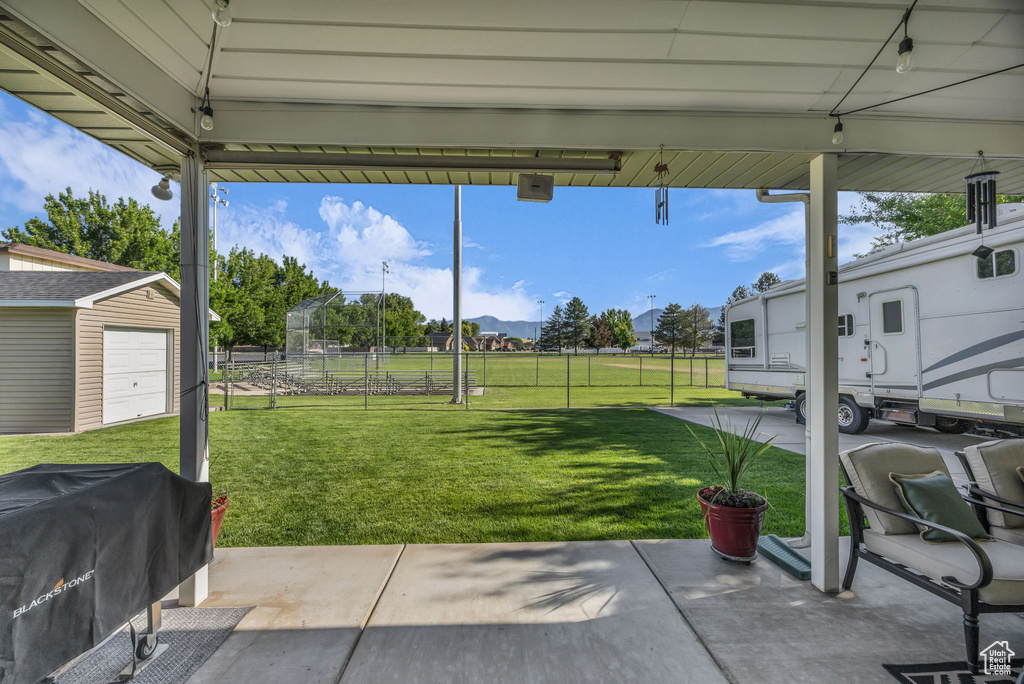 View of patio / terrace with grilling area, a garage, a mountain view, and an outdoor structure