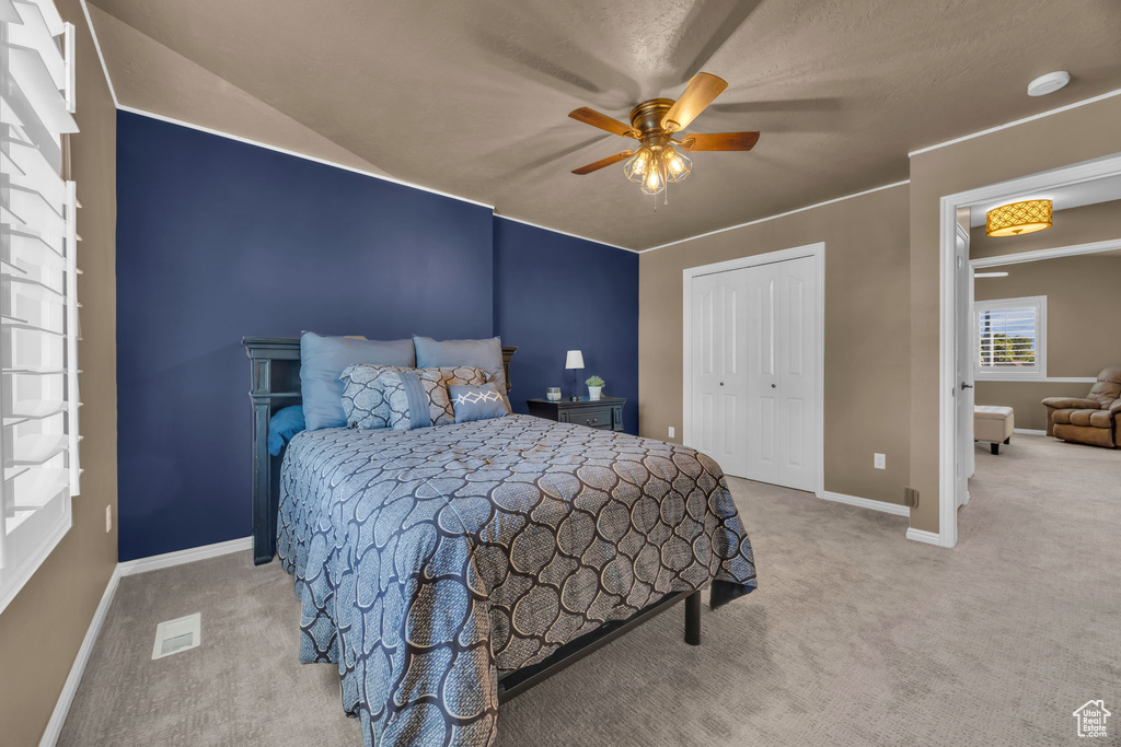 Bedroom with carpet, baseboards, a closet, and a ceiling fan