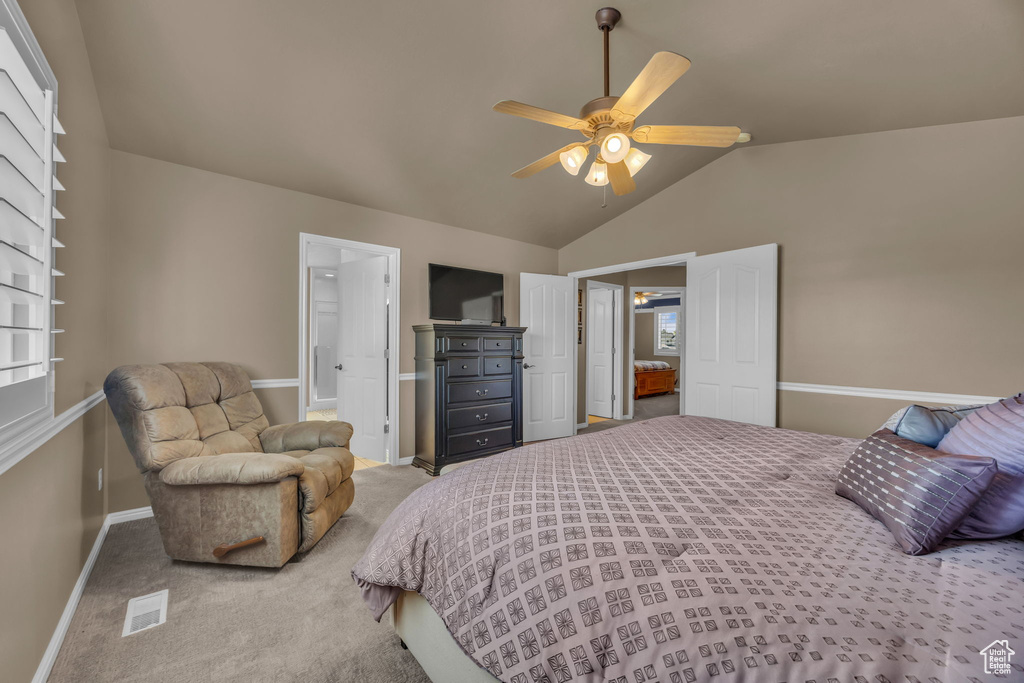 Bedroom featuring carpet flooring, vaulted ceiling, baseboards, a ceiling fan, and connected bathroom