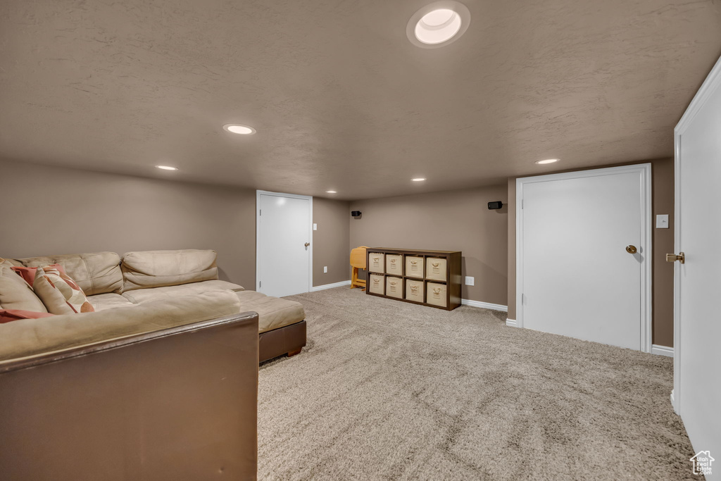 Carpeted living area with recessed lighting and baseboards