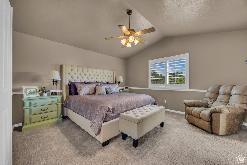Bedroom featuring vaulted ceiling, light colored carpet, a ceiling fan, and baseboards