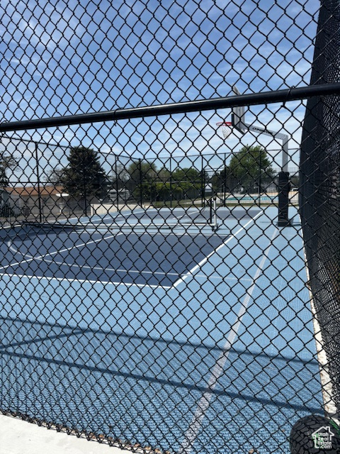 View of tennis court featuring fence