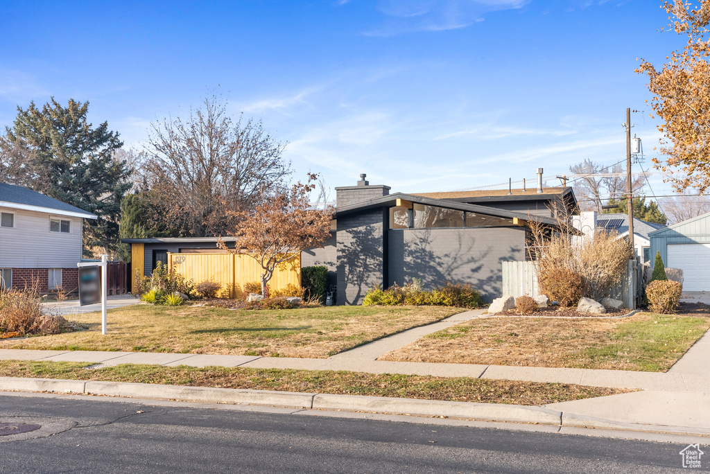 Mid-century inspired home with a chimney and a garage