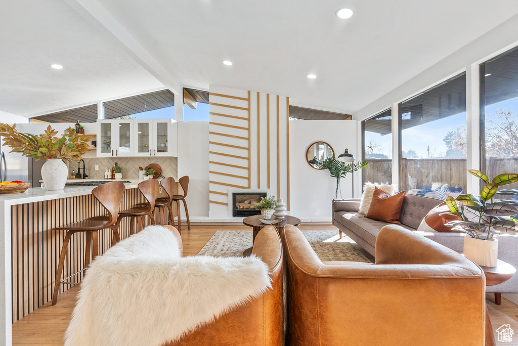 Living room featuring light wood finished floors, recessed lighting, and a fireplace