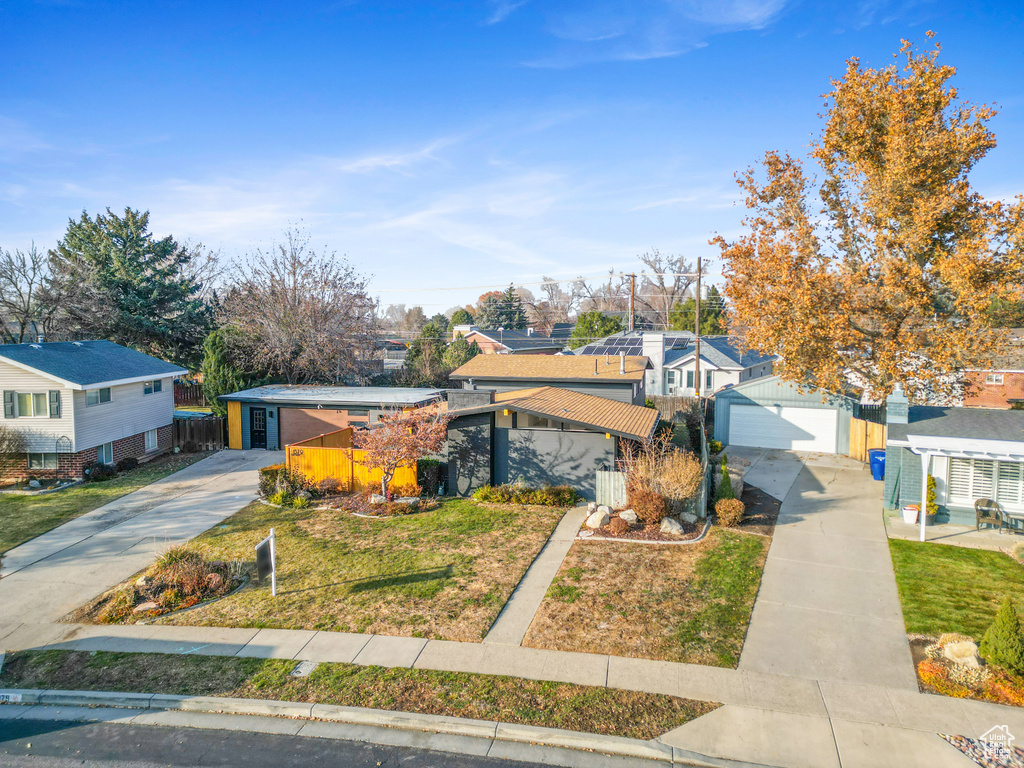 Mid-century modern home featuring driveway, a garage, and a residential view