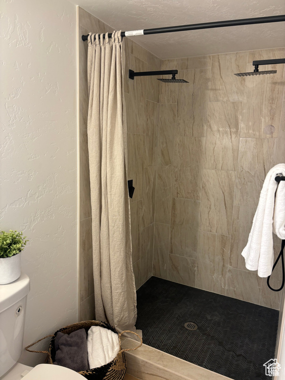 Full bathroom featuring toilet and a shower stall