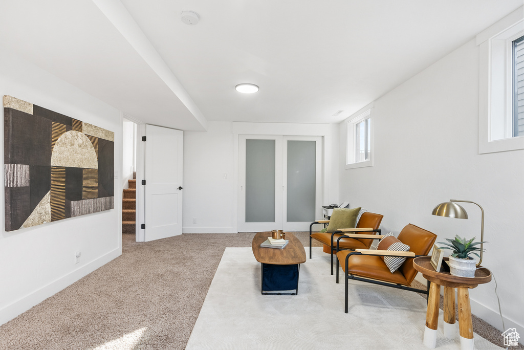 Living area featuring carpet flooring, stairs, and baseboards