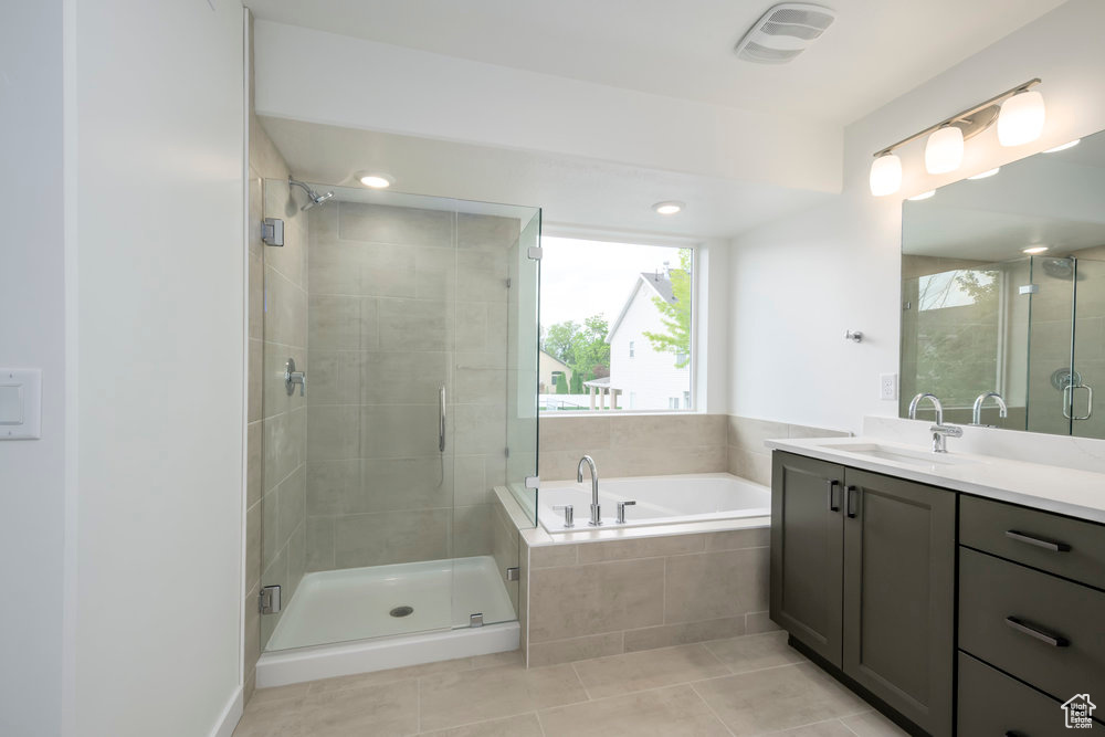 Bathroom with vanity, a garden tub, a stall shower, and tile patterned floors
