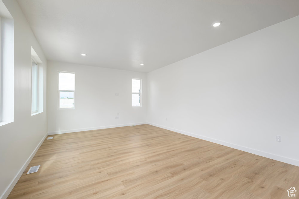Empty room with baseboards, light wood-style flooring, and recessed lighting