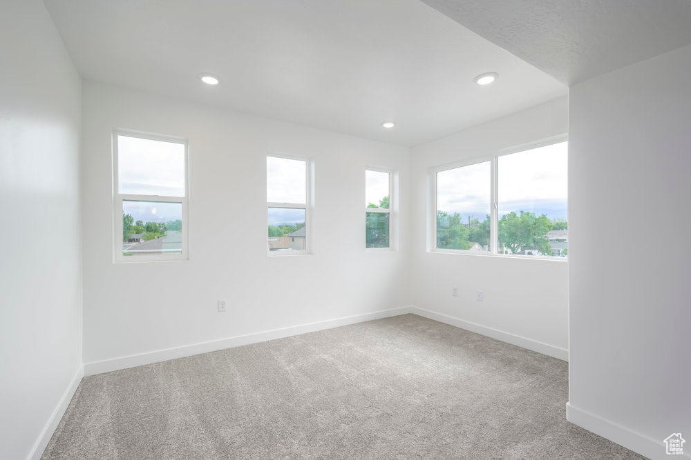 Carpeted empty room with baseboards and recessed lighting