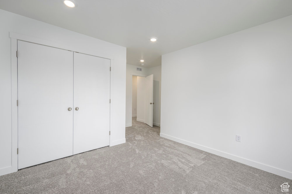 Unfurnished bedroom with recessed lighting, carpet flooring, a closet, and baseboards