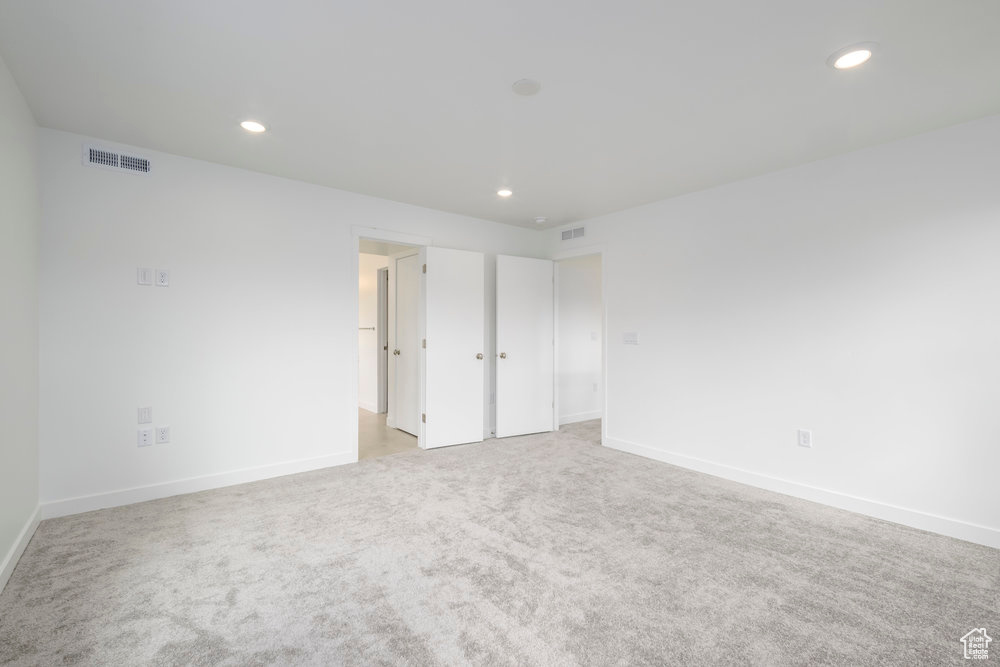 Unfurnished bedroom with light colored carpet, recessed lighting, and baseboards