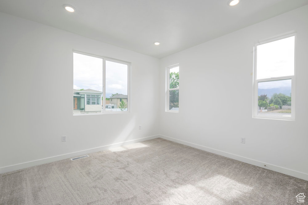 Empty room with carpet floors, baseboards, and recessed lighting
