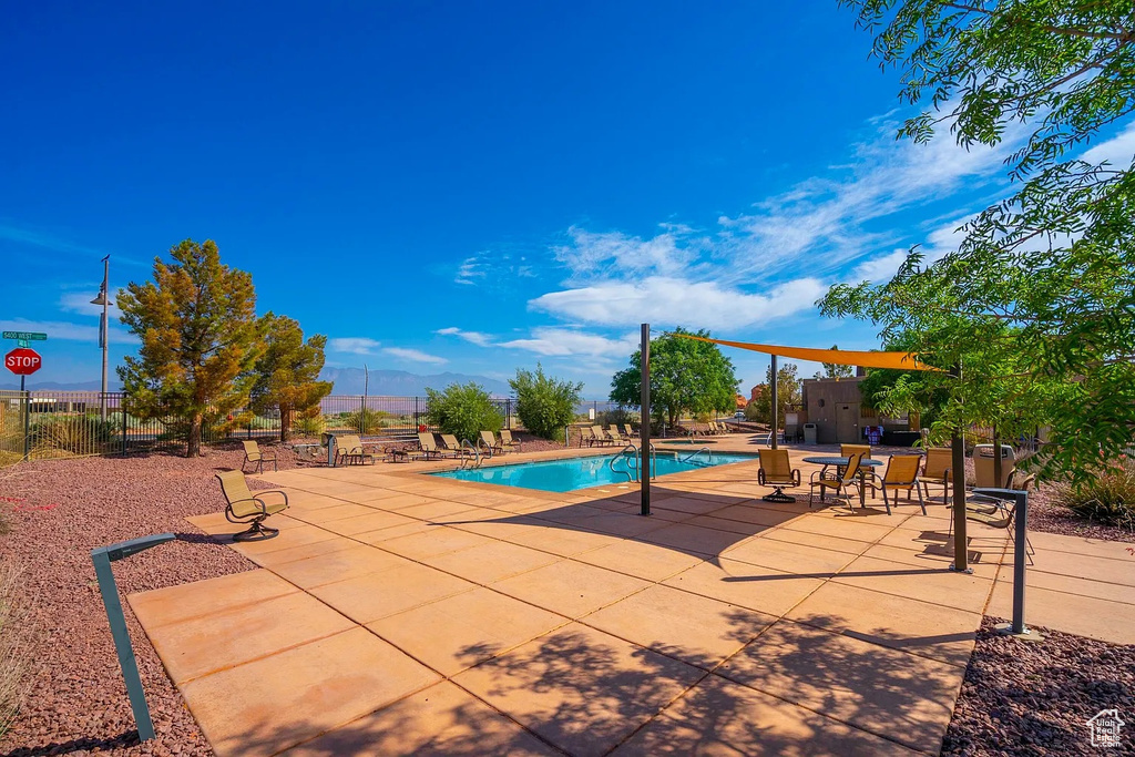 Pool with a patio area, an outdoor structure, a mountain view, a shed, and fence