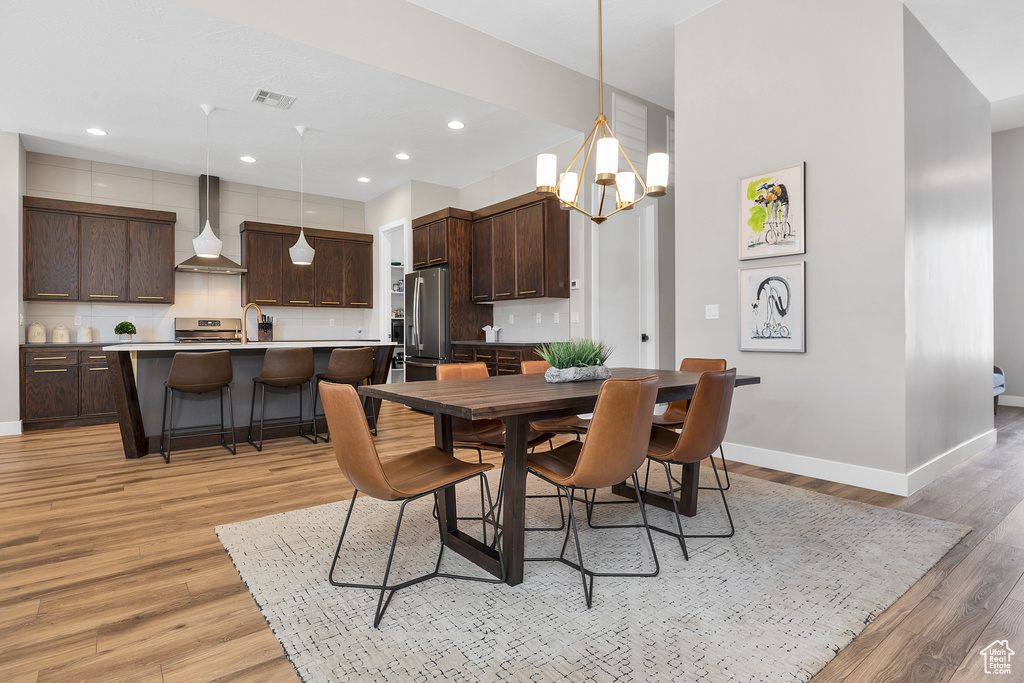Dining space featuring recessed lighting, an inviting chandelier, light wood-type flooring, visible vents, and baseboards