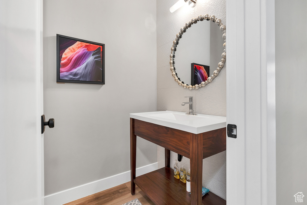 Bathroom featuring vanity, wood finished floors, and baseboards