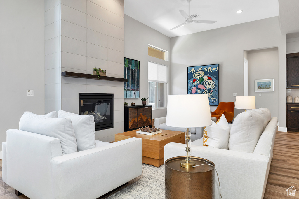 Living room featuring recessed lighting, wood finished floors, ceiling fan, and a fireplace
