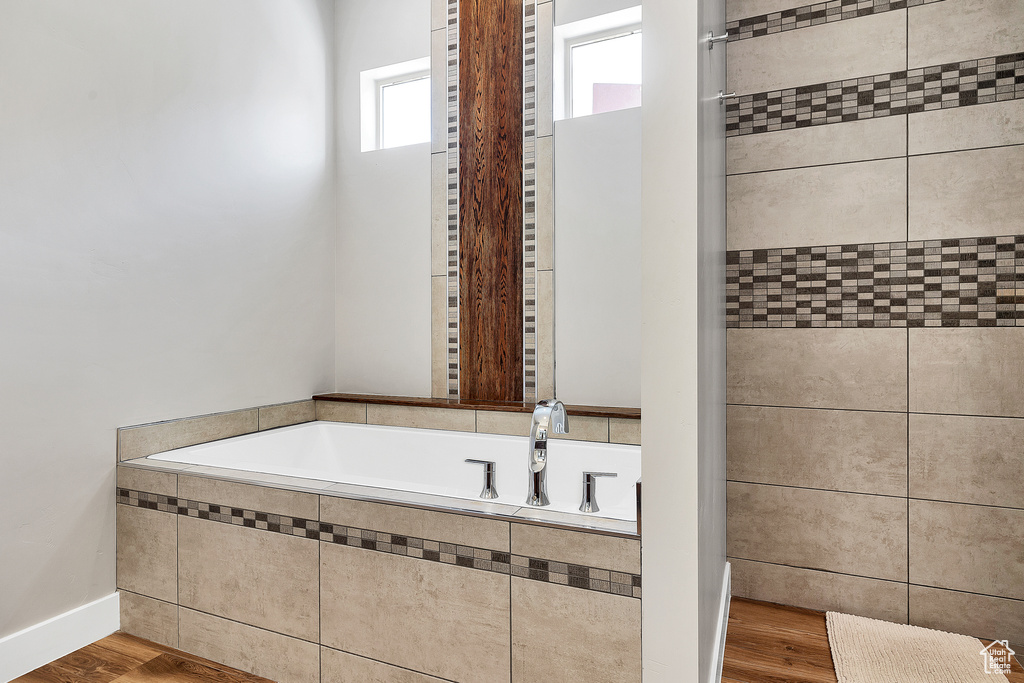 Full bath featuring wood finished floors and a garden tub
