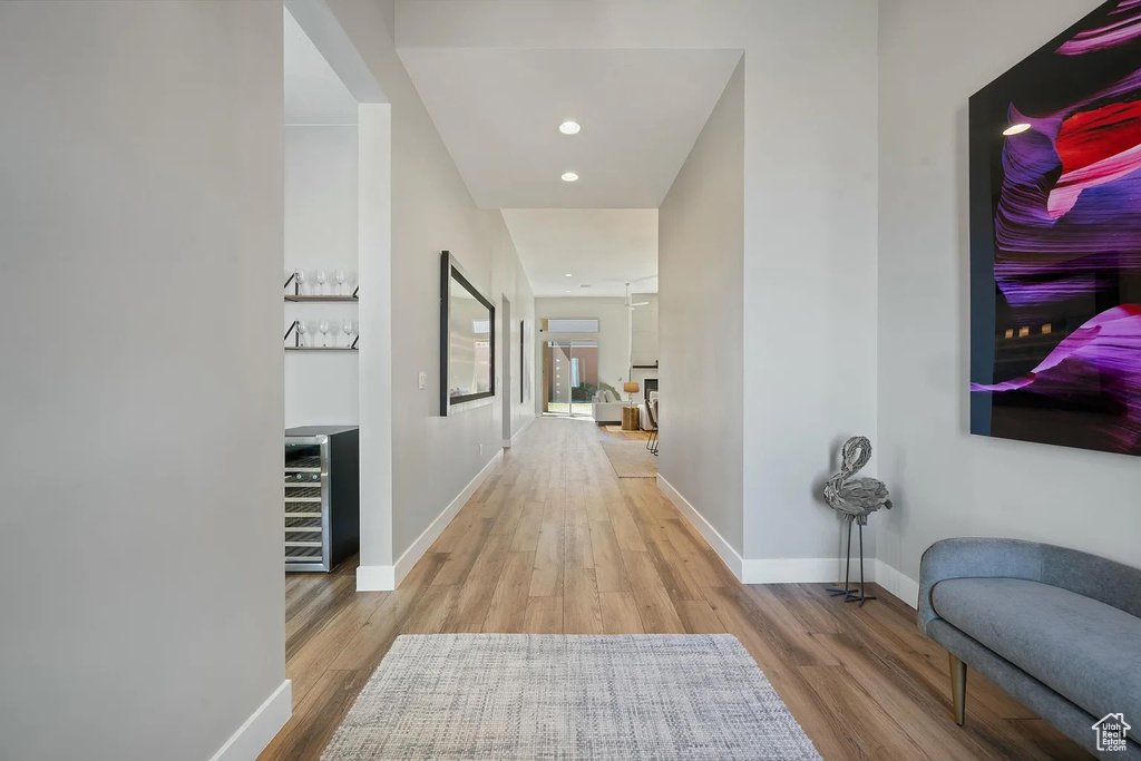 Hall featuring beverage cooler, wood finished floors, and baseboards