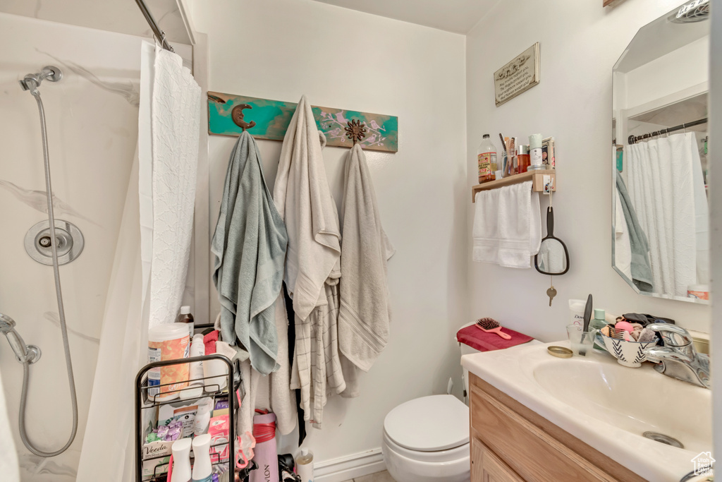 Bathroom featuring toilet, vanity, and a shower with shower curtain