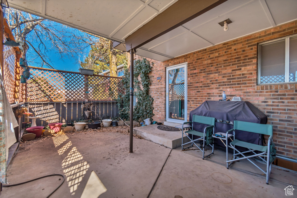 View of patio featuring fence and grilling area