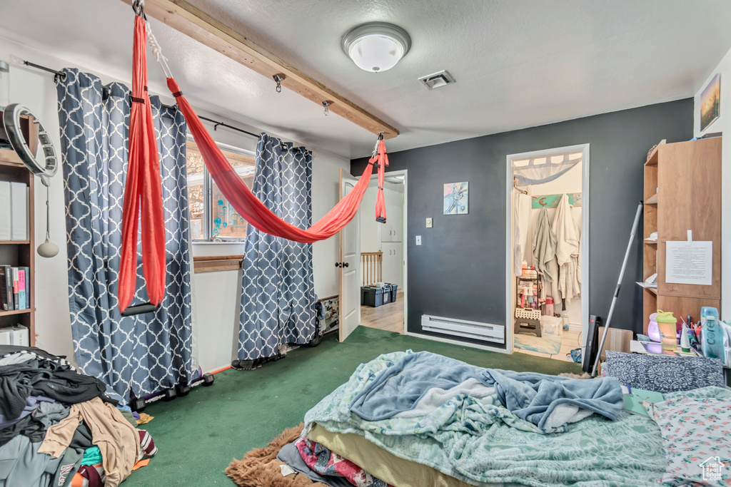 Bedroom with carpet floors, visible vents, and baseboard heating