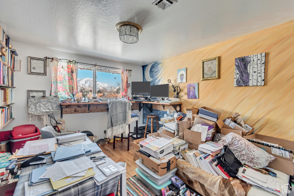 Home office with a textured ceiling, wood finished floors, and visible vents