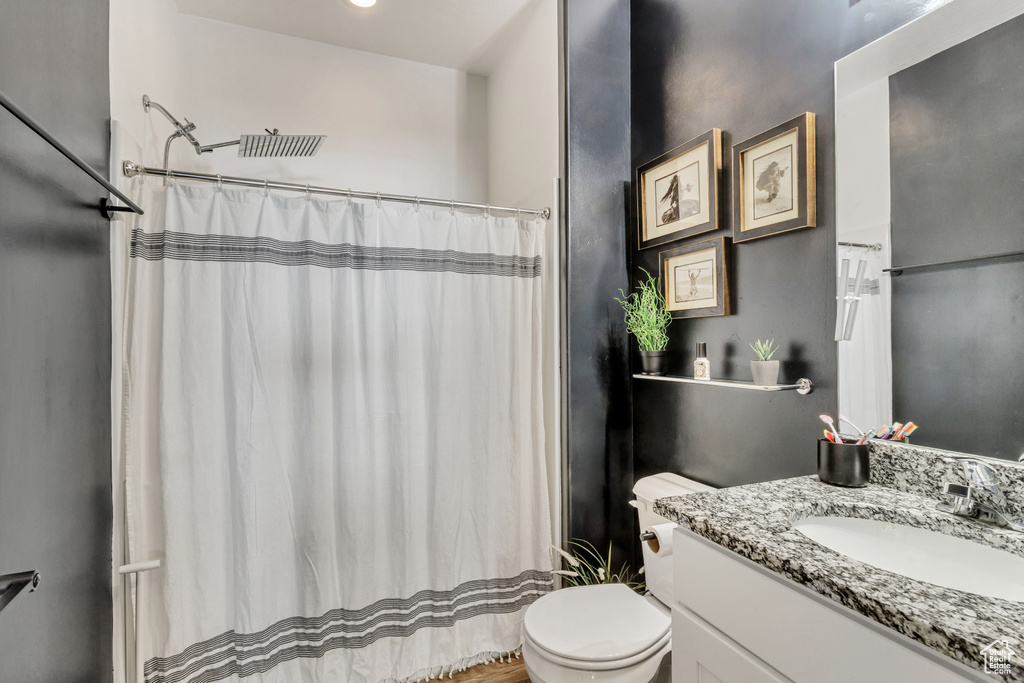 Full bathroom with a shower with shower curtain, vanity, and toilet