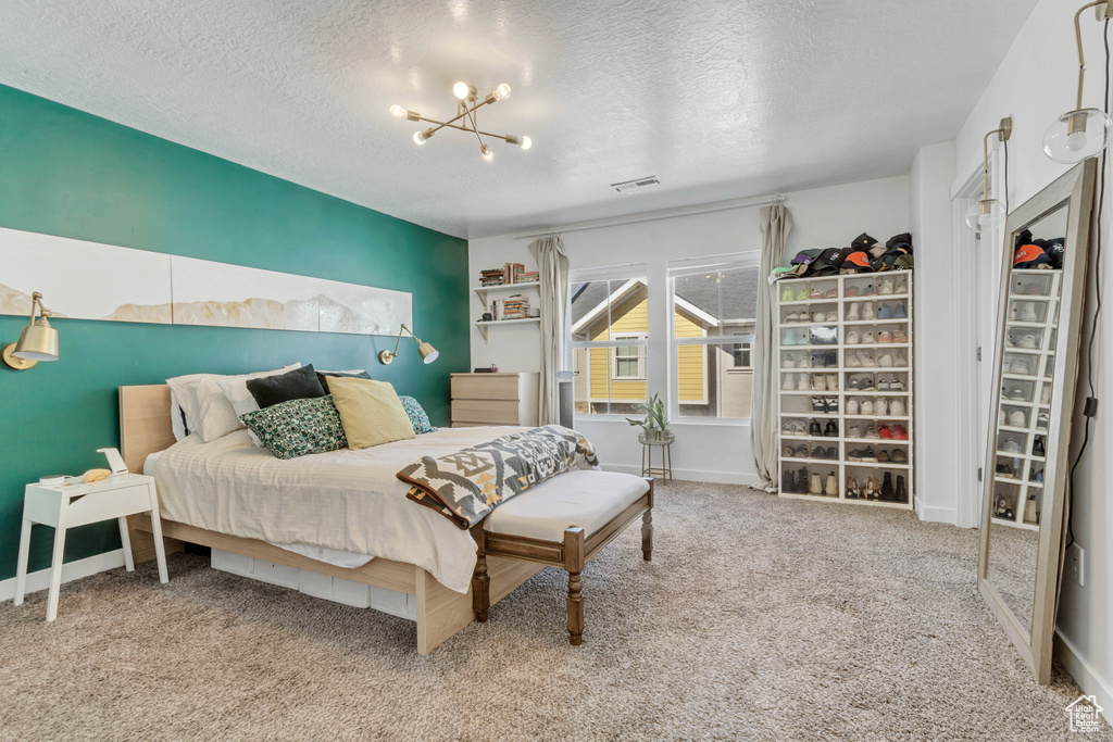 Bedroom featuring baseboards, carpet, visible vents, and a textured ceiling