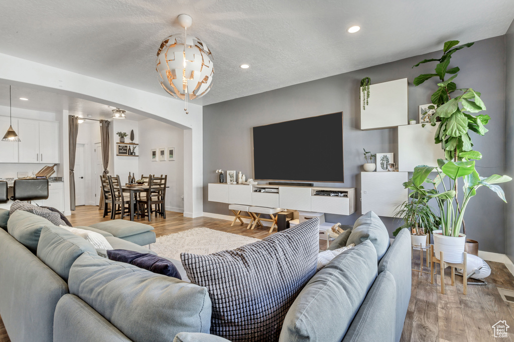 Living area with light wood-type flooring, baseboards, and recessed lighting