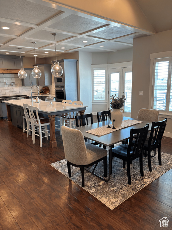 Dining area with dark wood-style floors, coffered ceiling, beam ceiling, and recessed lighting