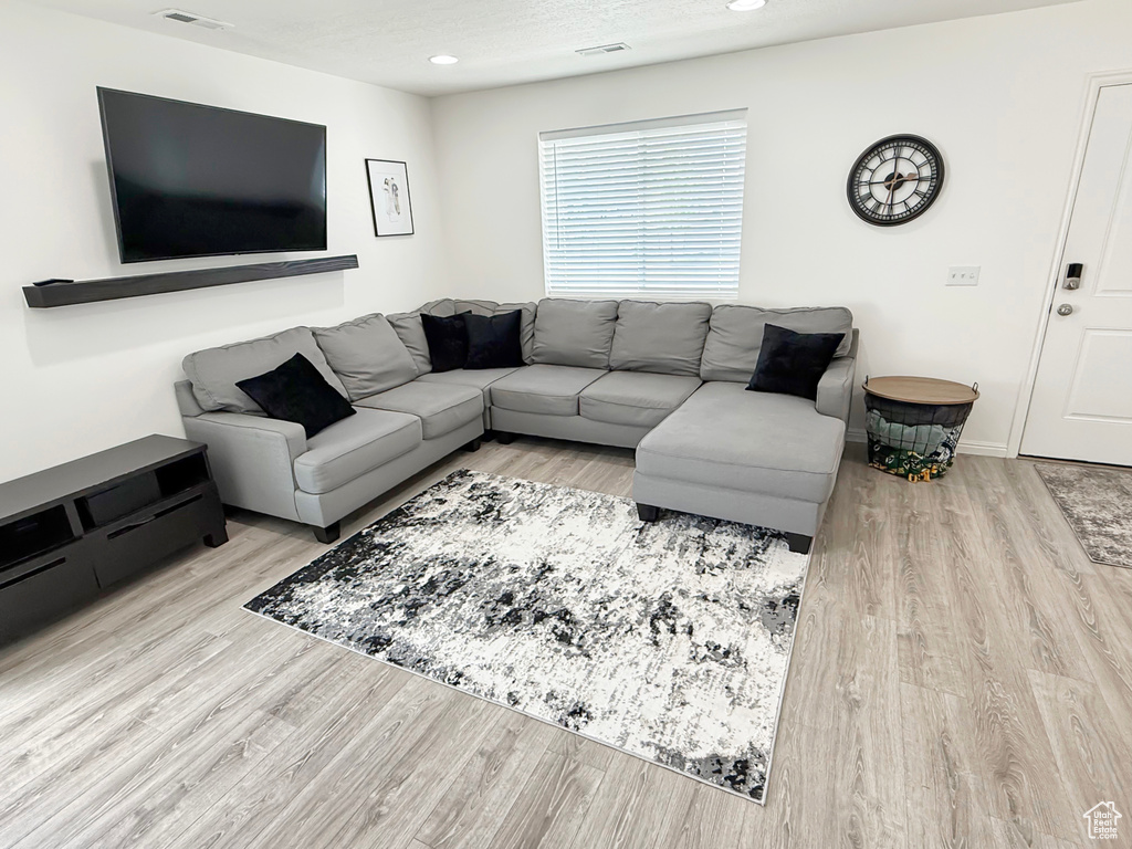 Living area featuring wood finished floors, recessed lighting, and baseboards