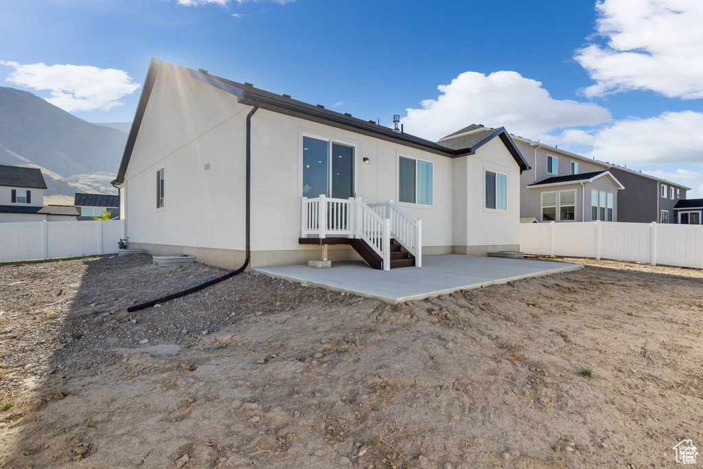 Rear view of house with a patio area, fence private yard, and a mountain view