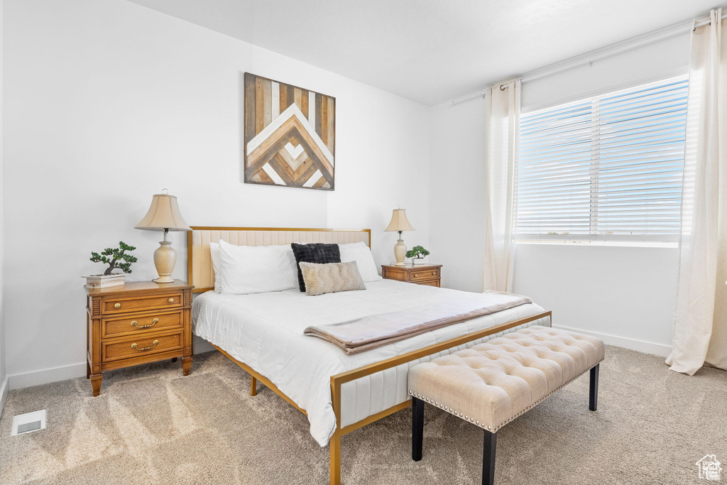 Bedroom with baseboards, visible vents, and carpet flooring