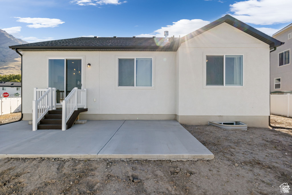 Back of property featuring a patio area, fence, and stucco siding