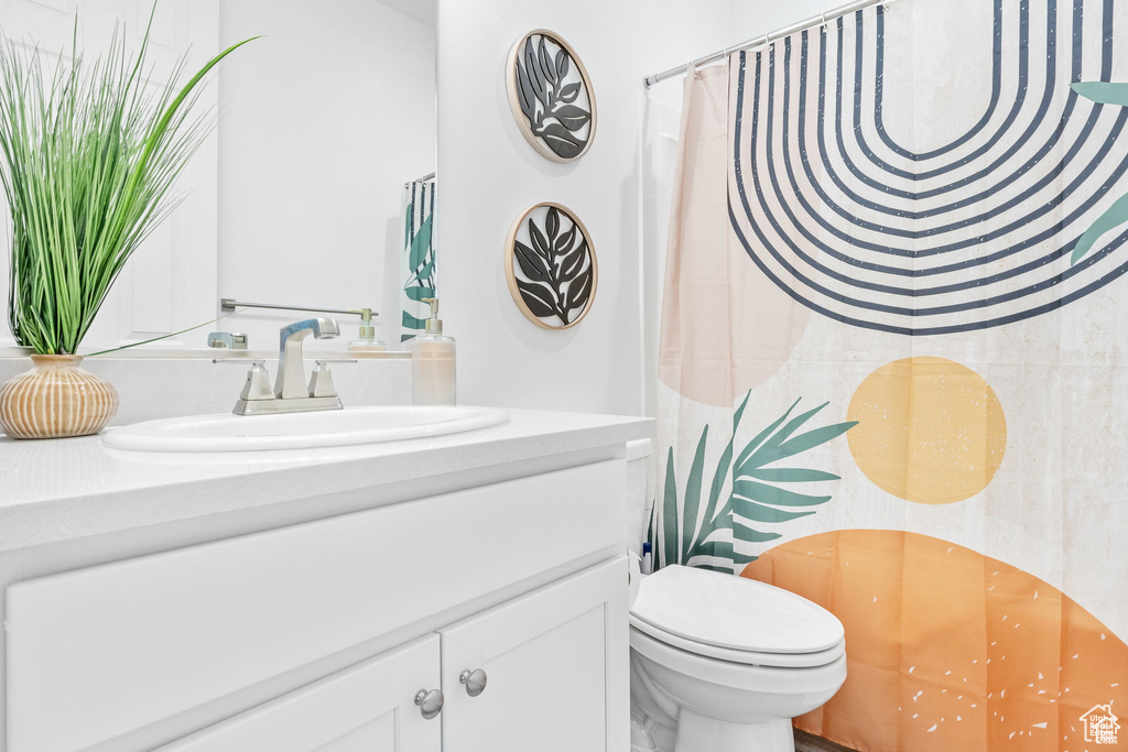 Full bath featuring toilet, vanity, and a shower with curtain