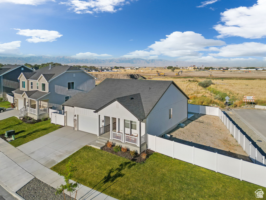 Modern farmhouse with roof with shingles, concrete driveway, a garage, fence private yard, and a front lawn