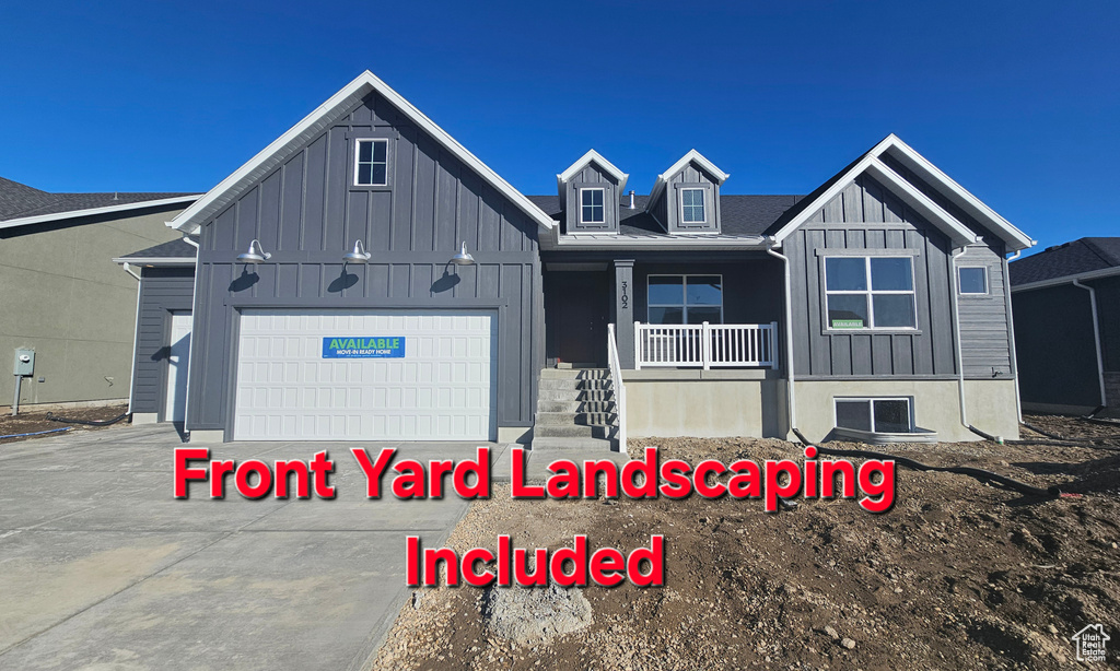 View of front facade featuring driveway, a porch, board and batten siding, and an attached garage
