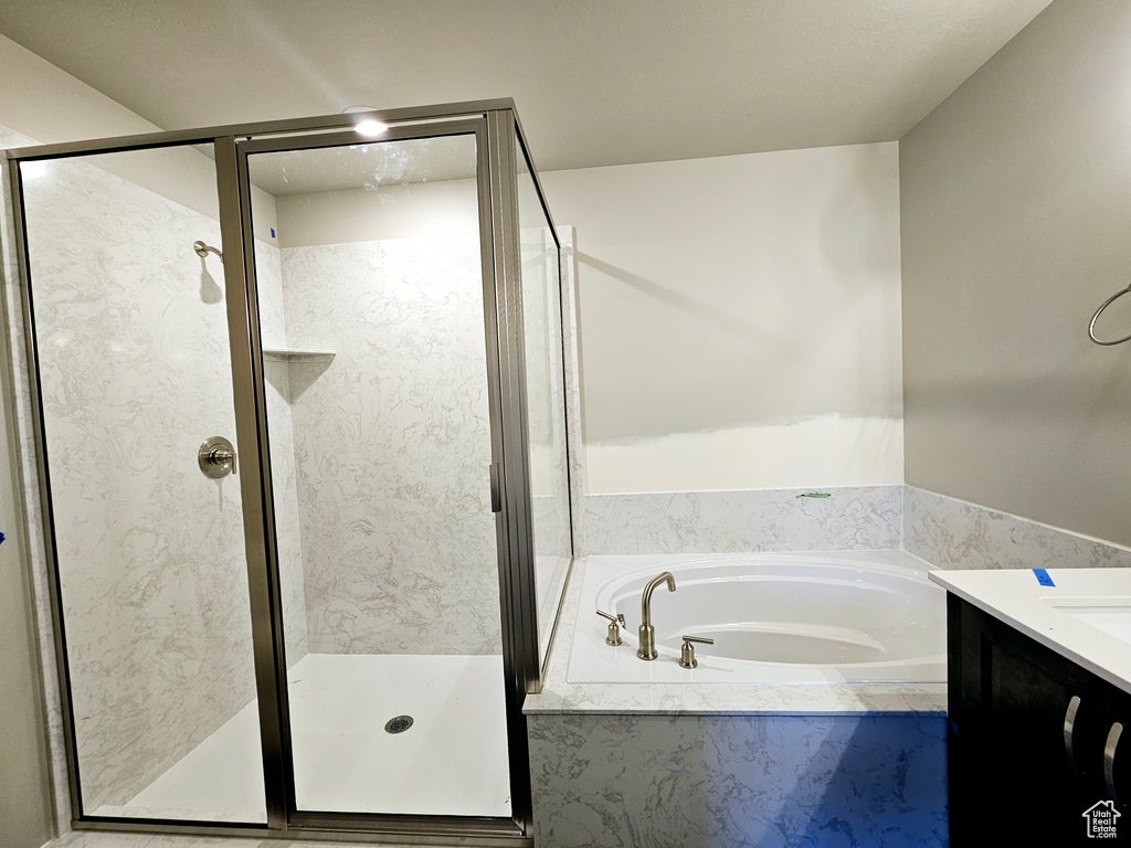 Bathroom with a shower stall, vanity, and a bath