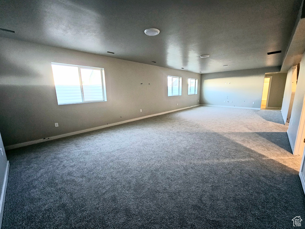 Carpeted empty room with baseboards