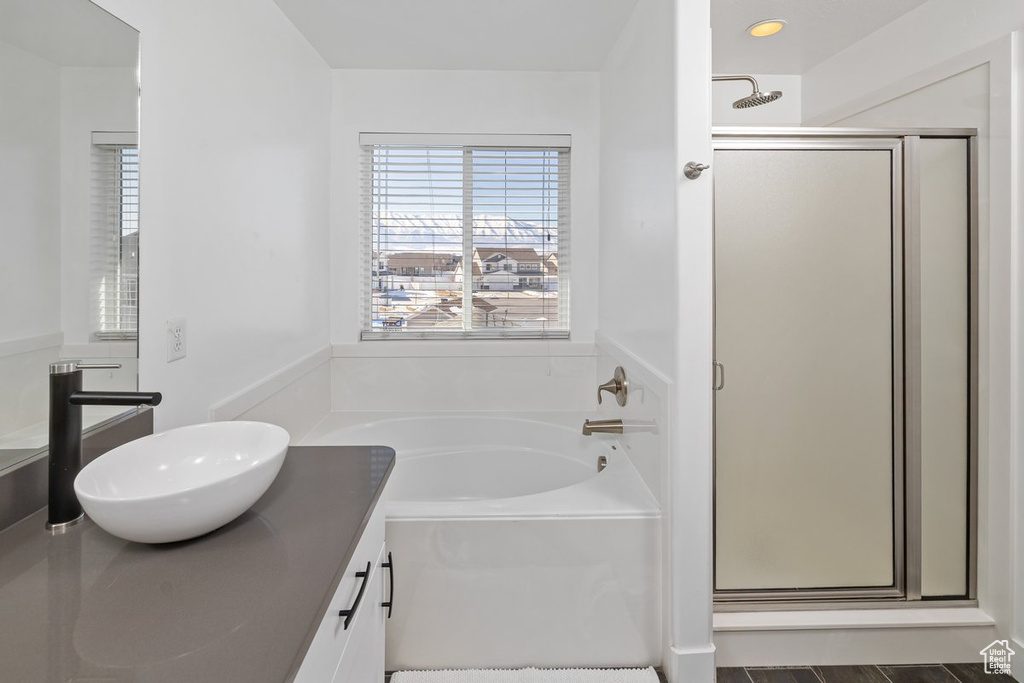 Full bathroom featuring vanity, a shower stall, and a bath